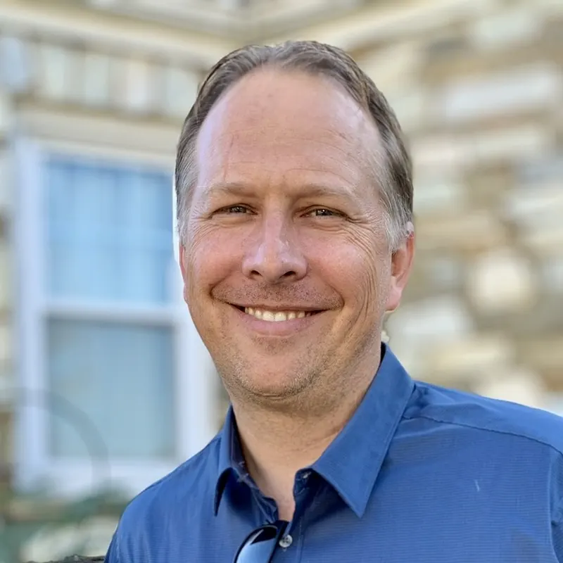 Rev. Ryan Irmer, smiling, in a blue collared shirt.